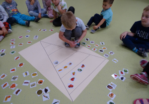 Dzieci układają produkty na piramidzie żywienia